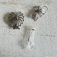 Three vintage brooches laid flat showing size and design details.