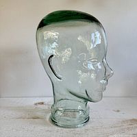 Side profile of the vintage glass mannequin head showing tint and texture