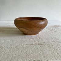 Front view of the wooden bowl showing its rounded shape and wood grain finish.