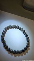 Top view of the natural yooperlite bead bracelet laid flat in a circle under neutral light.