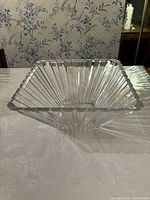 Clear square crystal bowl displayed from top angle on white surface.