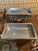 Stainless steel chafing dish showing pan and stand, taken from above to show pan depth and shape.