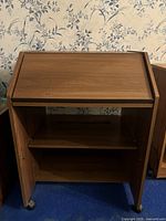 Closed desk showing the wooden top front and side doors with wheels.