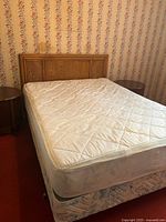 Queen bed frame with mattress and box spring, headboard shown attached to frame