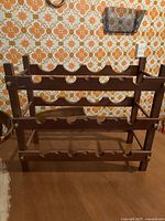 Front view of two wooden tabletop wine racks showing three tiers each with semi-circular bottle slots.