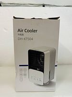 Front view of the boxed DH-KTS04 Air Cooler showing product image and model number.