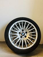 Front view of BMW alloy wheel with mounted tire showing multi-spoke design and center cap.