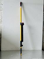 Full view of the yellow Rubbermaid commercial mop extension handle against a plain background.