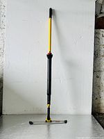 Full view of the Rubbermaid Pulse microfiber floor mop showing yellow handle, black mop frame, and mop head.