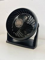 Front view of black Honeywell small desk fan, showing circular grille, fan blades, and logo.