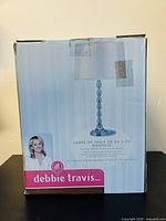 Front of original box showing Debbie Travis branding and lamp image