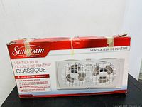 Front view of retail box showing Sunbeam branding and twin fans inside a white frame.