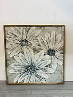 Frontal view of square framed flower painting showing three large white flowers with textured petals and dark centers on muted gray-green background