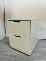 Front view of white IKEA cabinet showing two drawers with recessed handles