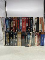 Front view of the VHS lot, all shrink wrapped showing various movie titles neatly arranged in two rows.