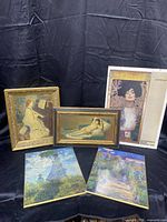 Five art prints arranged with a black backdrop showing a variety of styles and frames