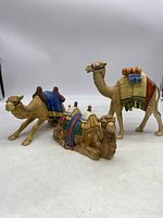Three camel figurines grouped on table