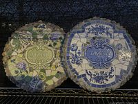 Two round mosaic stone wall plaques with floral designs and 'Jardin' label, shown side by side.