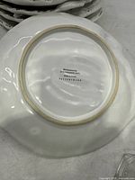 Back side of one white ceramic salad plate showing microwave and dishwasher safe markings and Pottery Barn branding.