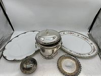 Overall view showing two oval China serving platters, the silver-plated ice bucket, small covered dish, and decorative round dish.