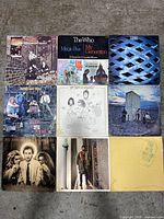 Top-down view of all 9 vinyl albums arranged in a 3 by 3 grid on the floor showing front album covers.