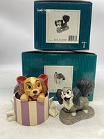 Two Walt Disney Classics Collection dog figurines with original boxes, showing Lady in a gift box and Flirtatious Fifi standing on a base.