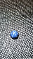 Photo showing the round blue star sapphire cabochon on a textured black surface with visible 6-ray star effect.