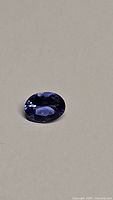Front view of oval tanzanite on neutral background showing color and cut