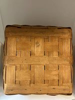 Bottom view of the square woven wood basket showing the construction detail, securing nails, and 'Longaberger 1990' inscription.