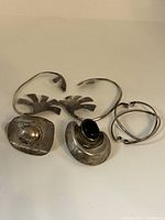 Top view of six silver earrings showing different designs including clip-on and hoops