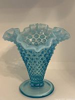 Front view of blue Fenton glass vase showcasing hobnail texture and ruffled rim.