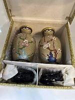 Two vintage cloisonné vases stored inside a decorative box with protective packing and two wood stands wrapped separately.