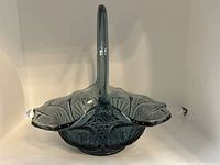 Side angled view of the blue glass basket showing handle and cut glass patterns