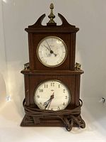 Full view of vintage wooden barometer and clock set with metal accents and attached electric cord for clock.