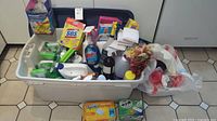 Wide view of the large white bin filled with various cleaning items including sprays, gloves, sponges, and more.