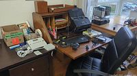 Overall view of desk area showing chair, desk hutch, scanner, keyboard and office supplies