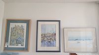 Three framed watercolour paintings hung on a wall, showing all items in the lot