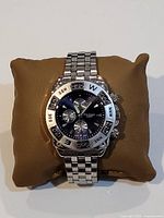 Front view of the vintage wristwatch on a cushion, showing the watch face, bezel, and band.