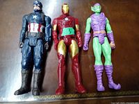 Three Marvel action figures displayed side by side: Captain America, Iron Man, and Green Goblin.