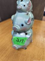 Front side view of ceramic piggy bank showing three stacked pigs with the phrase 'For My Vacation' and green label with 217.
