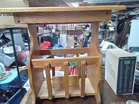Front view of wooden telephone table with integrated magazine rack at the bottom, showing wood finish and structure.