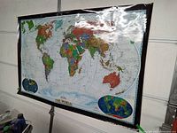 Full view of the laminated world map showing all continents and bordered with black tape.