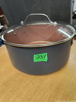 Close-up of a large round Gotham pot with glass lid and metal handle