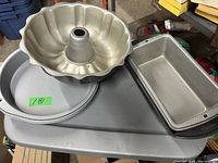 Photo showing metal bakeware including a Bundt pan on top of two round pans and two rectangular loaf pans to the right.