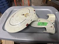 Image showing top-down view of the white NCC-1701-D starship model with clearly visible saucer section and secondary hull with nacelles.