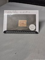 Photo showing the Canadian 5 cent Beaver stamp mounted on a white card with handwritten notes including 'Canada #15 issued 1859' and pricing info, labeled Lot 301.