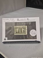 Stamp in protective sleeve with handwritten note indicating Scott Catalog #100 and year issued as 1908.