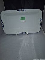 Top view of the rectangular white ceramic serving dish with blue and beige floral designs on the rim edges, showing the textured base interior.