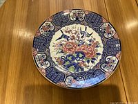 Front view of the Japanese porcelain charger plate showing floral and bird design with detailed colorful patterns on the rim and center.