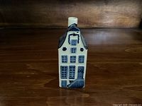 Front view of KLM Dutch House figurine showing detailed windows, door, and roof design in blue on white porcelain.